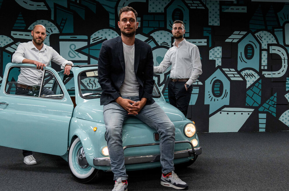 Die ads&figures Gründer vor dem Fiat 500 im Büro